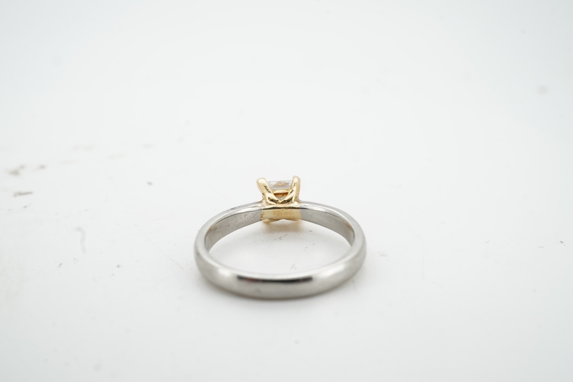 A diamond ring, claw-set with a princess-cut diamond weighing approximately 0.58 carats, mounted in platinum, size F1/2, British hallmarks, gross weight approximately 2 grams